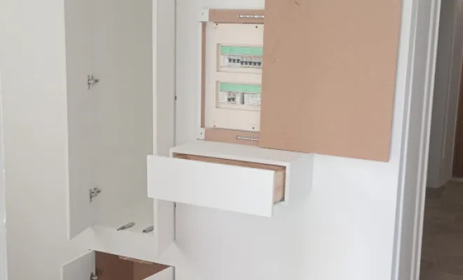 réalisation meuble de rangement encastré avec portes affleurantes et masquage tableau électrique par un tableau coulissant..